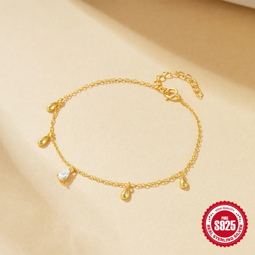 Gold colour sterling silver bracelet with geometric water drop diamond pendant on model wrist