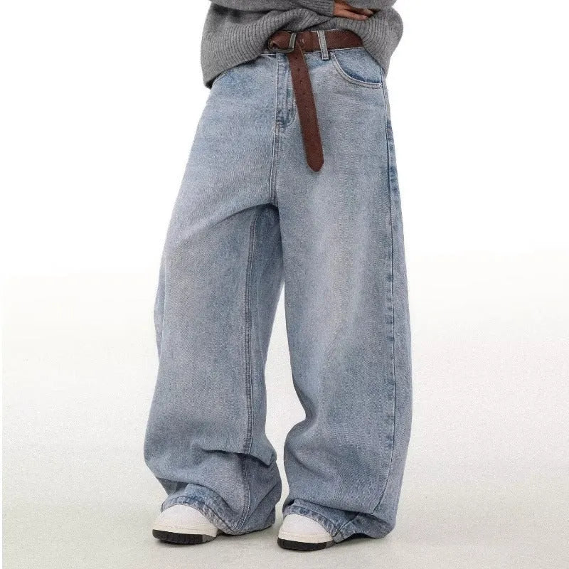 Man wearing retro blue washed straight leg distressed jeans with a mid-rise waist.