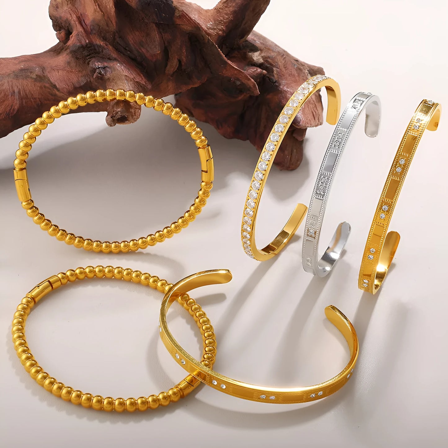 Stainless steel open-end bracelet with a buckle clasp in a choice of gold, silver, or zirconium gold electroplated finishes.