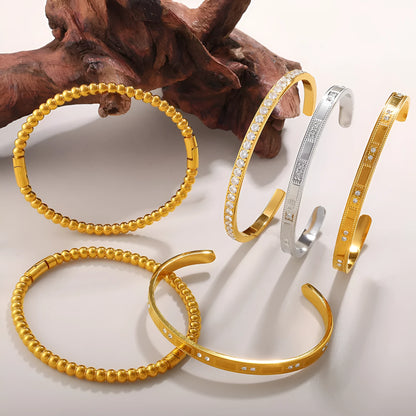 Stainless steel open-end bracelet with a buckle clasp in a choice of gold, silver, or zirconium gold electroplated finishes.