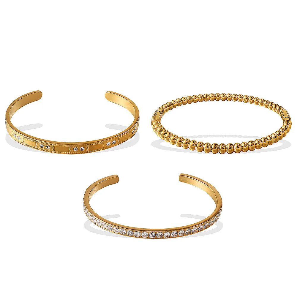 Stainless steel open-end bracelet with a buckle clasp in a choice of gold, silver, or zirconium gold electroplated finishes.