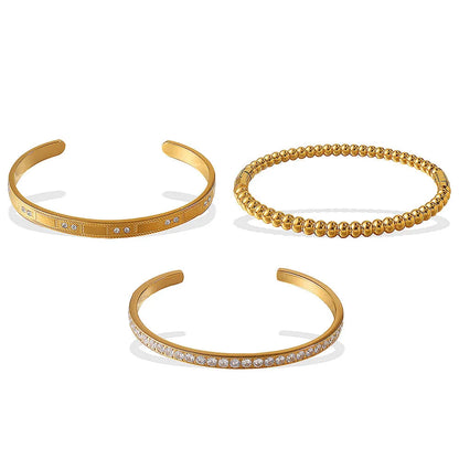 Stainless steel open-end bracelet with a buckle clasp in a choice of gold, silver, or zirconium gold electroplated finishes.