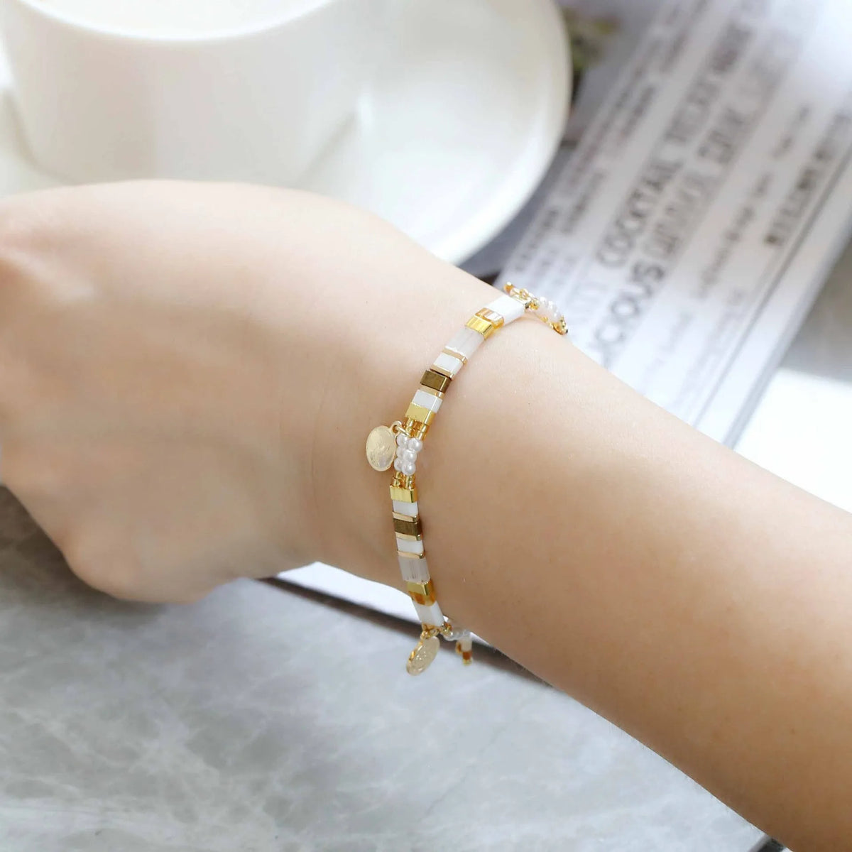 Women's adjustable bracelet with handcrafted imitation pearl beads in a glass-coloured finish.