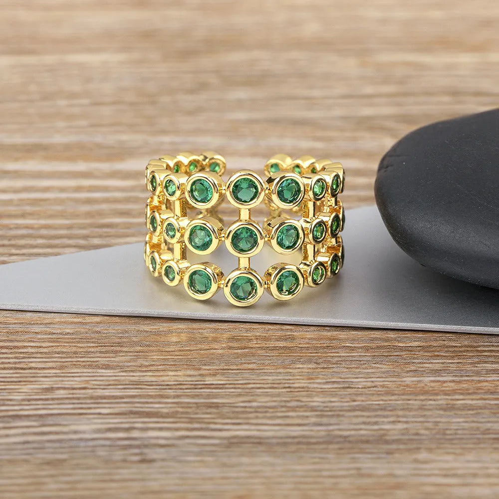 Wide gold-plated copper ring with three-layer design and a large green zircon stone.