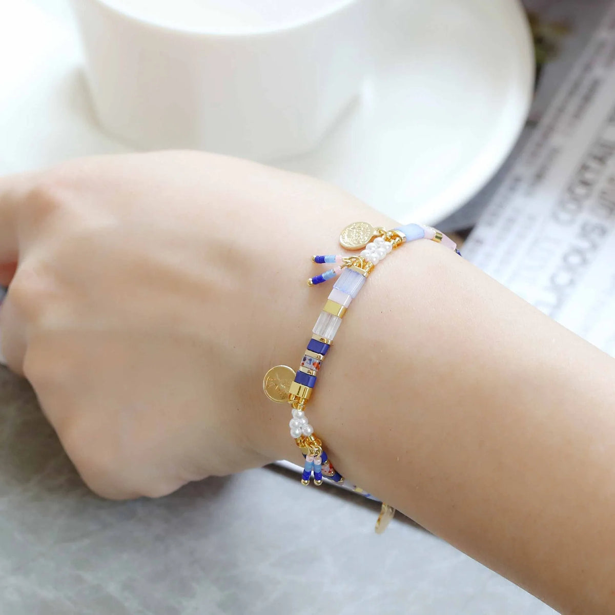 Women's adjustable bracelet with handcrafted imitation pearl beads in a glass-coloured finish.