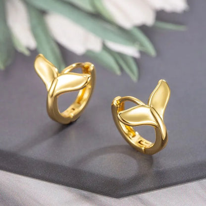 A pair of simple fishtail design earrings with an electroplated metallic finish, shown in white gold and yellow gold colour options.