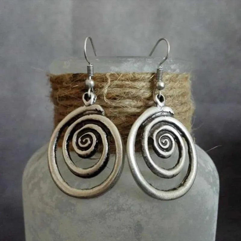 Retro geometric spiral earrings with a distressed silver finish.