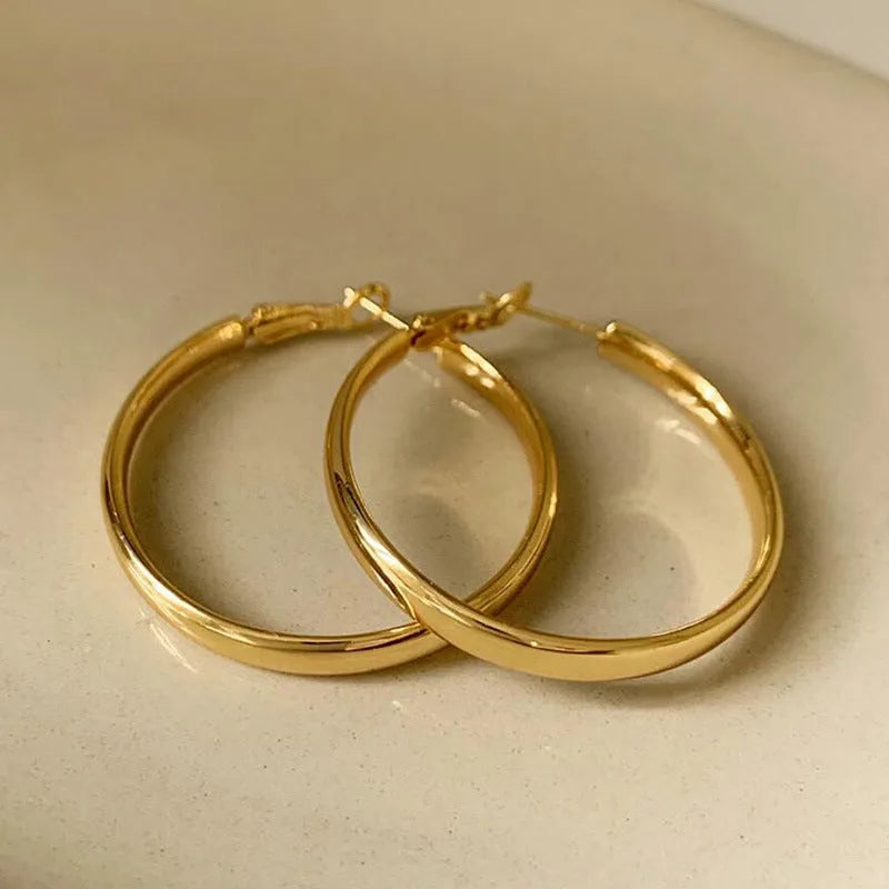 A pair of large, circular metal earrings in gold or silver colour, measuring 40mm.