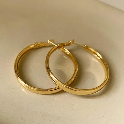 A pair of large, circular metal earrings in gold or silver colour, measuring 40mm.