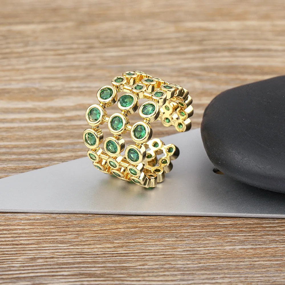 Wide gold-plated copper ring with three-layer design and a large green zircon stone.