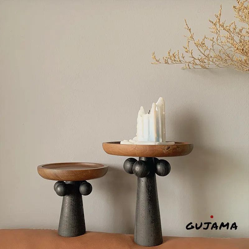 Round beech wood tray with high legs for candles and aromatherapy accessories on wooden table