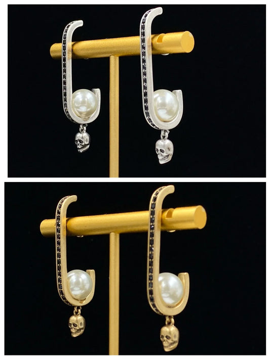 Pair of gold-tone earrings with a skull-shaped design, featuring pearls and diamonds