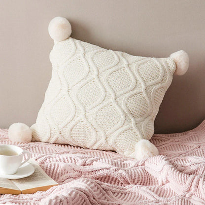 A cosy, knitted Nordic-inspired wind ball pillow in a neutral white colour, perfect for adding a touch of Scandinavian style to your living room decor.