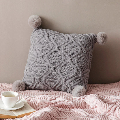 A cosy, knitted Nordic-inspired wind ball pillow in a neutral white colour, perfect for adding a touch of Scandinavian style to your living room decor.