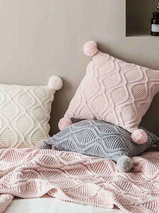 A cosy, knitted Nordic-inspired wind ball pillow in a neutral white colour, perfect for adding a touch of Scandinavian style to your living room decor.