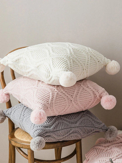 A cosy, knitted Nordic-inspired wind ball pillow in a neutral white colour, perfect for adding a touch of Scandinavian style to your living room decor.