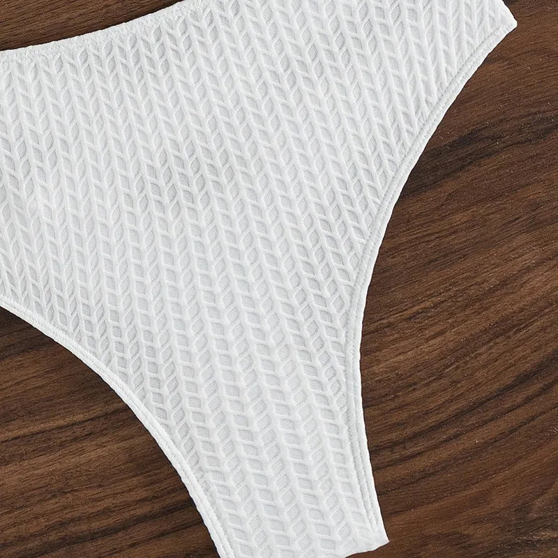 White women's backless bikini swimsuit with brief cut, laid flat showing bra and panties.