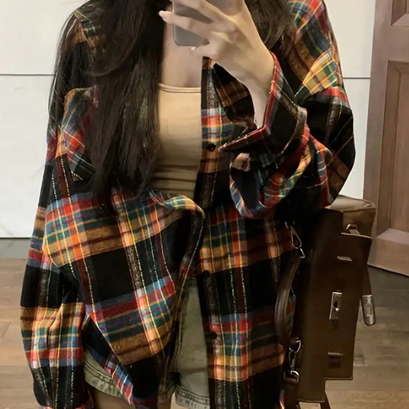 Woman wearing a loose-fit black and white plaid long sleeve shirt made from 100% cotton.