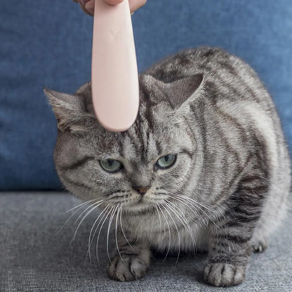 Grey and pink ABS plastic cat grooming comb with tongue-like texture and dual-ended design