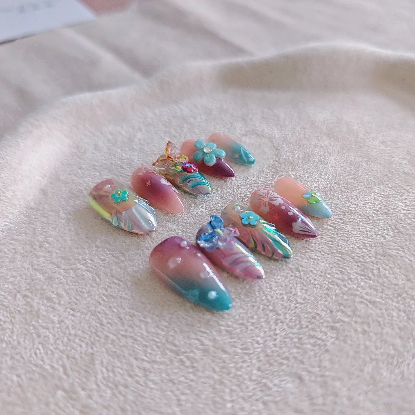 Handmade nail art sculpture set with embossed flower and butterfly designs in four sizes for almond-shaped nails