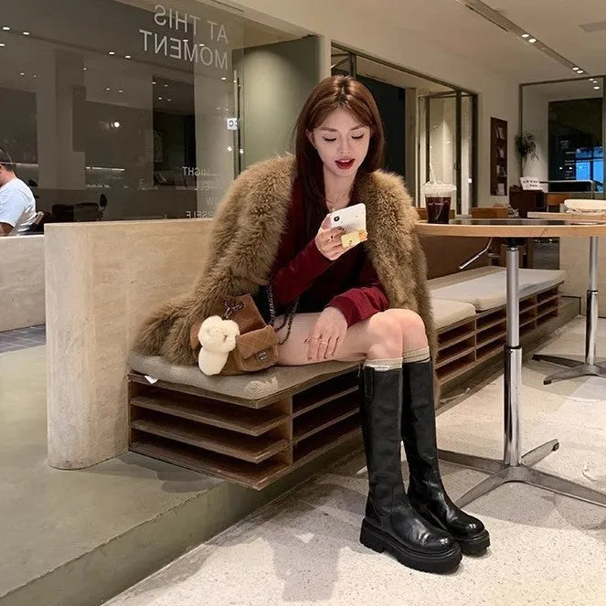 Round toe black chunky heel women's knight boots with a back zipper on a rubber sole.