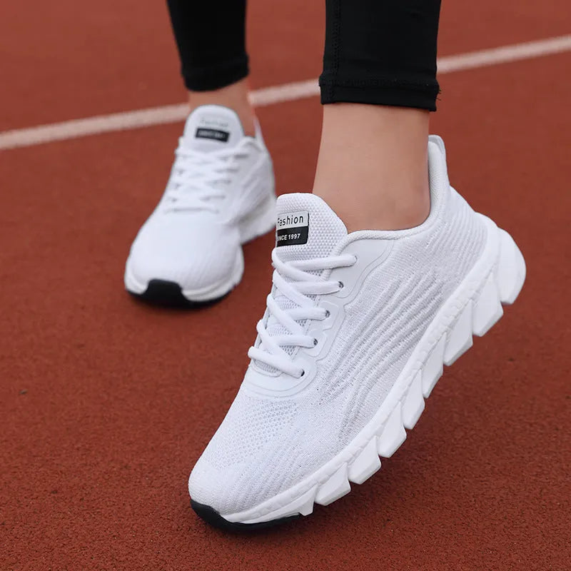 Women's casual flat sneakers for light running and jogging in black or white with low-top round toe and breathable MD sole construction available in sizes 36 to 44