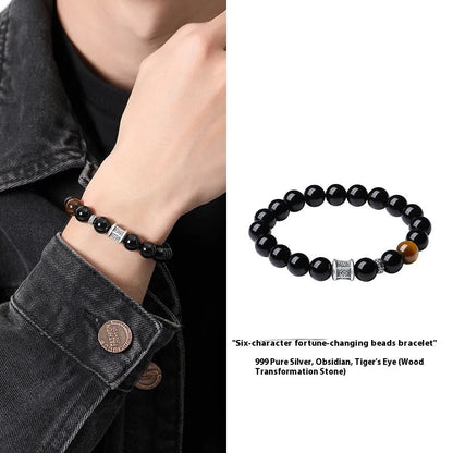 Men's black obsidian bracelet with 10mm prayer wheel beads and silver accents showing hand-woven construction
