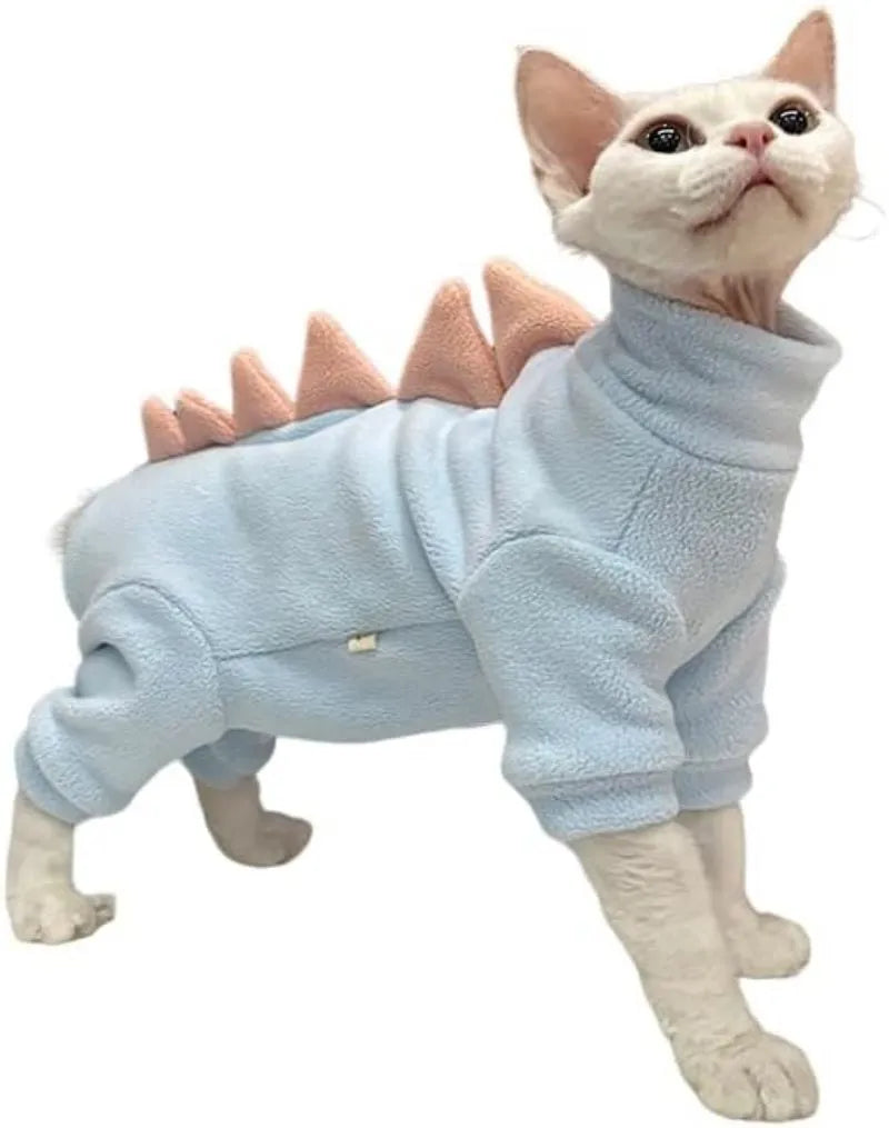 Sphynx cat wearing green dinosaur costume with tail and spikes