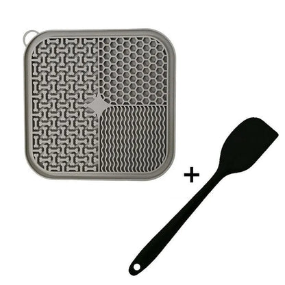 Square orange, grey, blue, and green silicone dog licking mat with suction cups on the base.