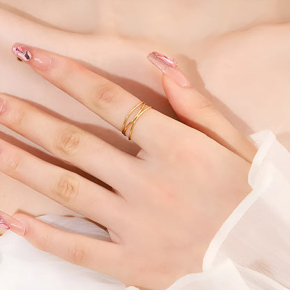 Gold titanium steel geometric coil ring with three-layer design on a model's finger.