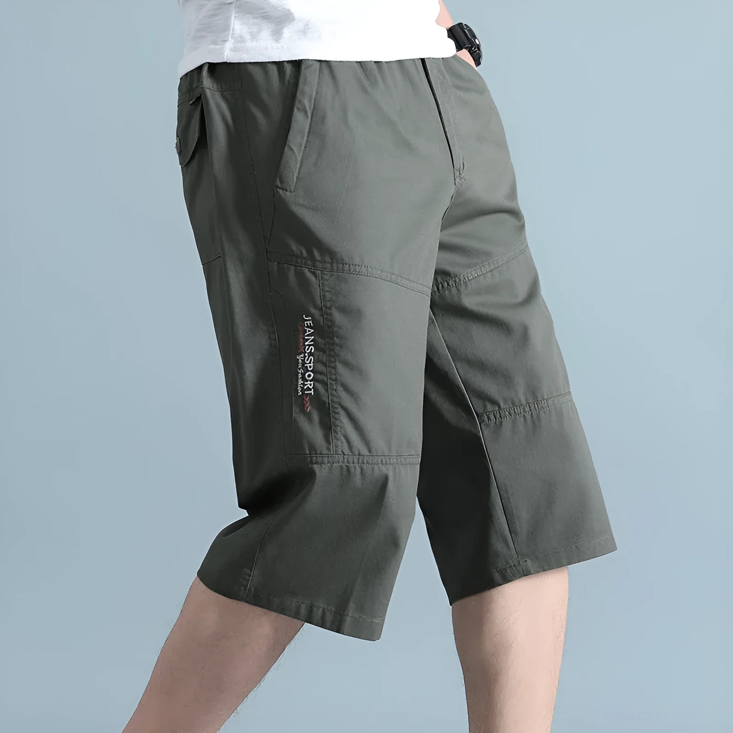 Man wearing loose grey cotton sports pants with a straight leg and cropped length.