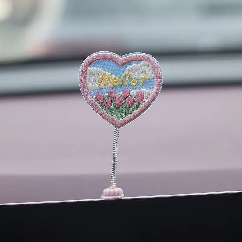 Set of six small yellow PVC duckling car decorations and one cartoon sign on a car dashboard.