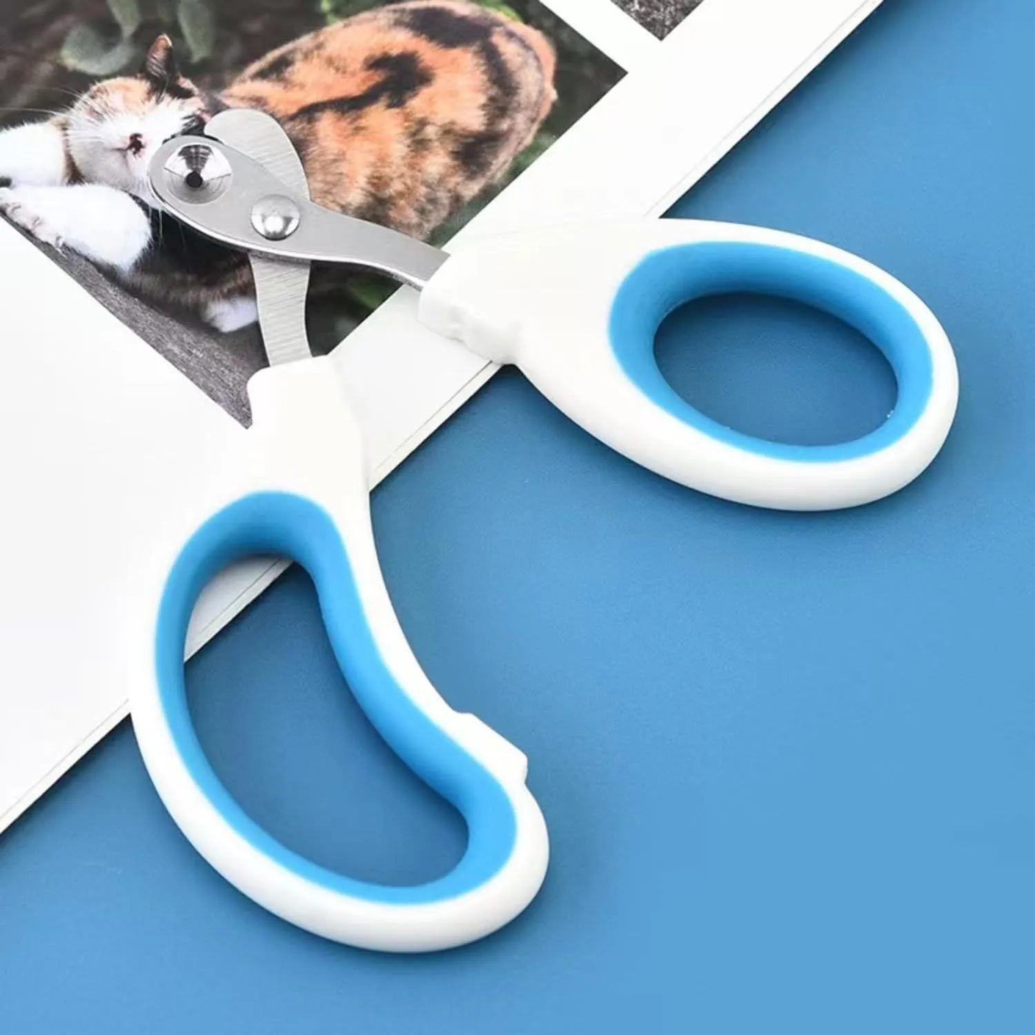 Blue cat nail clippers with a circular safety hole and cushioned non-slip grips on a white background.