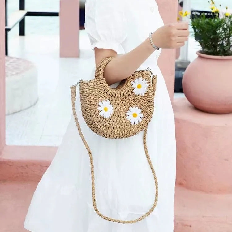 Women's light brown straw woven crossbody bag with daisy flower design showing 25x20x8 cm dimensions