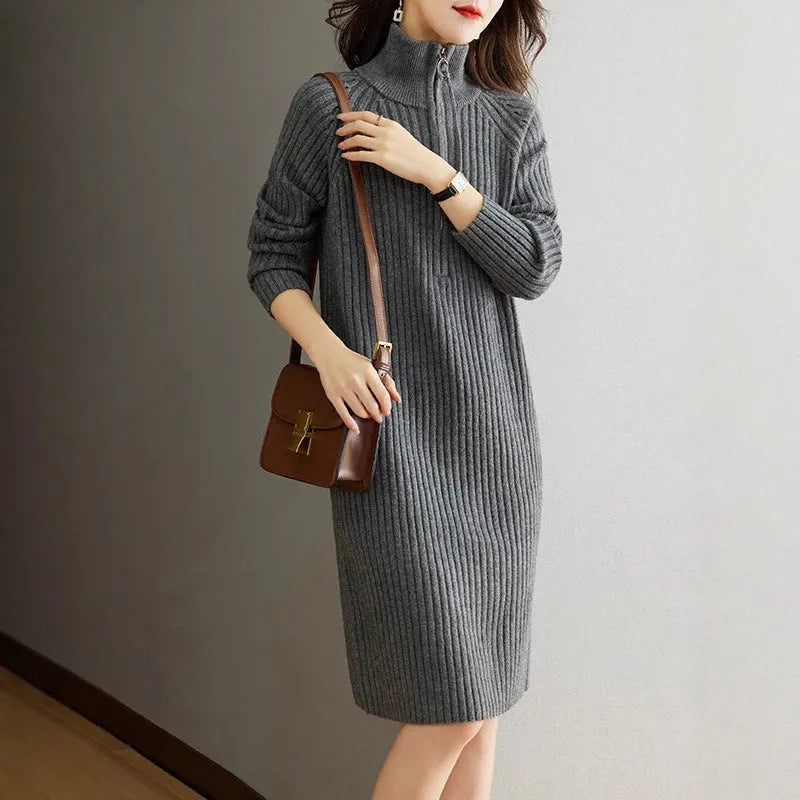 Beige half-zip woolen skirt with long sleeves, a stand collar, and a loose, straight midi silhouette.
