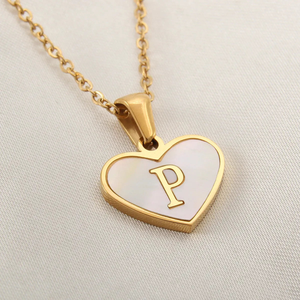 Gold-plated heart necklace with white shell pendant showing letter personalisation option