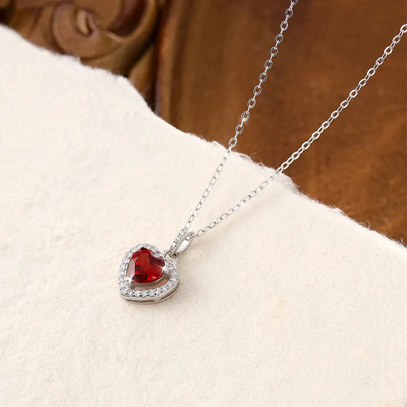 S925 sterling silver necklace with a heart-shaped pendant featuring a round natural gemstone on a cross chain.