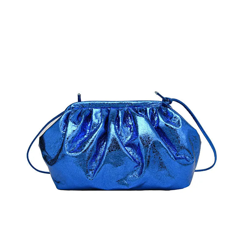 Rose red crossbody bag with hair clip strap clasp on a table, showing shell shape and front zipper.