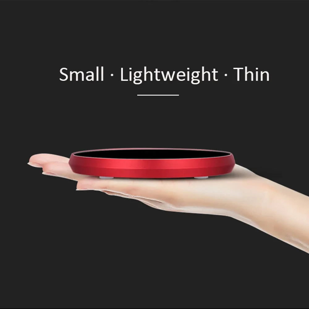 Black USB heating coaster with a mug on its tempered glass surface, showing a red LED indicator light.