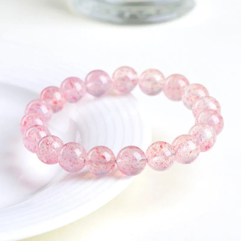 Unisex white strawberry quartz bracelet with round 10mm geometric beads on a string.