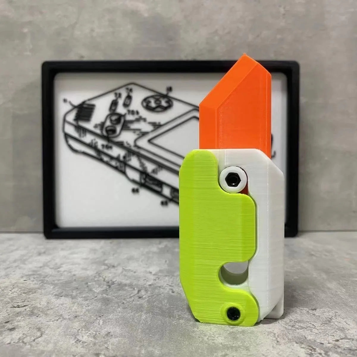 3D printed plastic carrot fidget knife with retractable blade, shown in orange and green colour scheme.