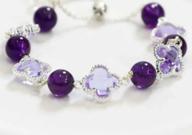 Women's artificial amethyst bracelet with U-shape design showing square stones, round stones, pearl and four-leaf clover charms