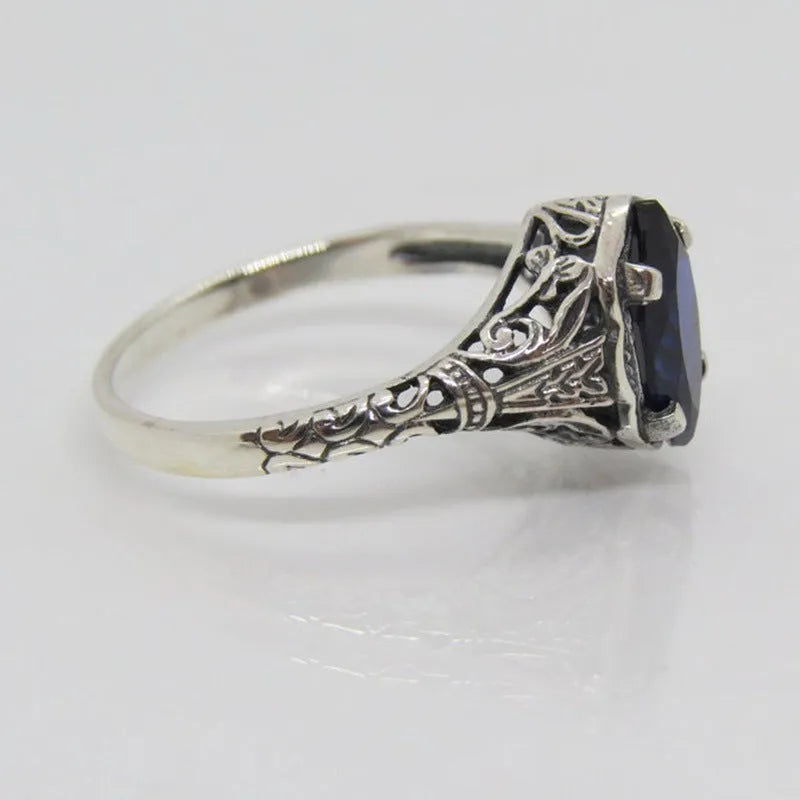 Silver women's ring with geometric hollow pattern and zircon detail on a finger.