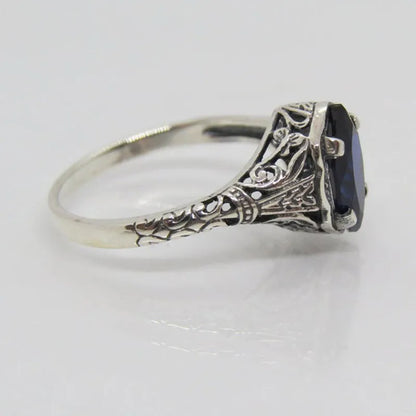 Silver women's ring with geometric hollow pattern and zircon detail on a finger.
