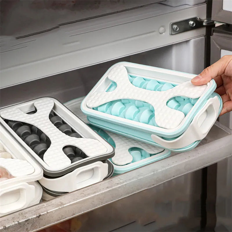 Light grey silicone ice ball mould and water bottle with lid on a kitchen counter.