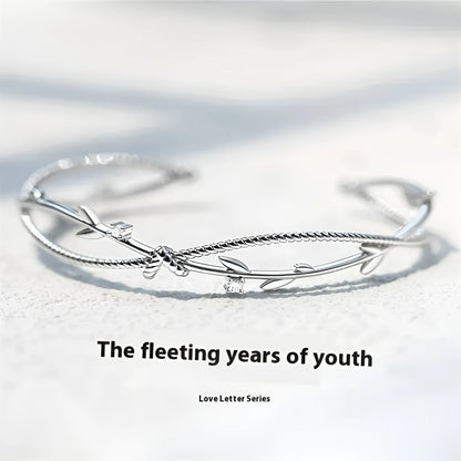 Copper ins style bracelet with detailed young tree branch and sprout cross twisted design in electroplated white gold colour.