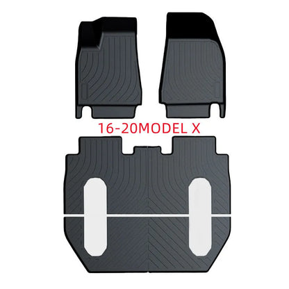Custom black rubber floor mats with textured surface and TPE driver's footrest, fitted in a Tesla interior.