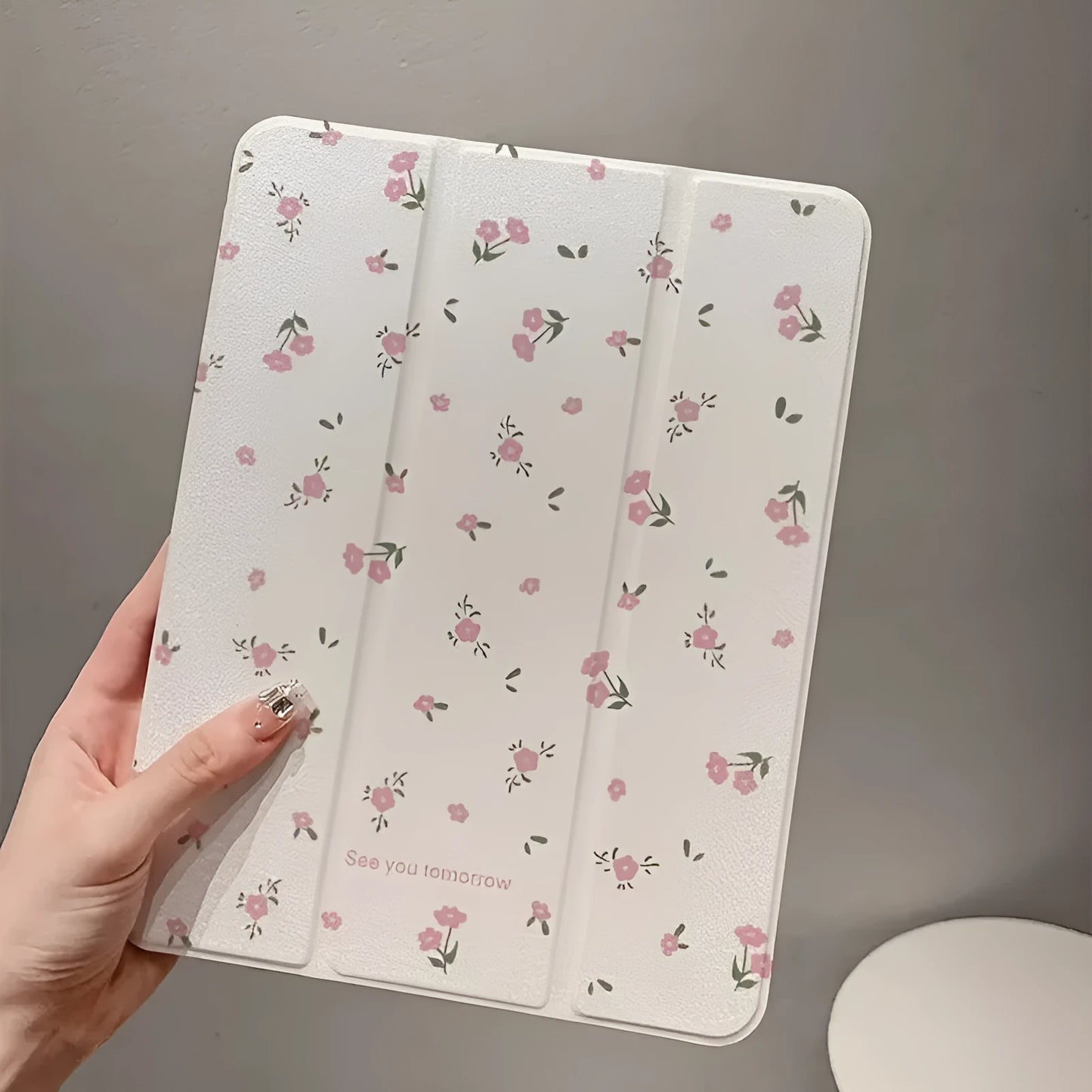 Transparent floral print hard case for iPad with tri-fold magnetic front cover acting as a kickstand.
