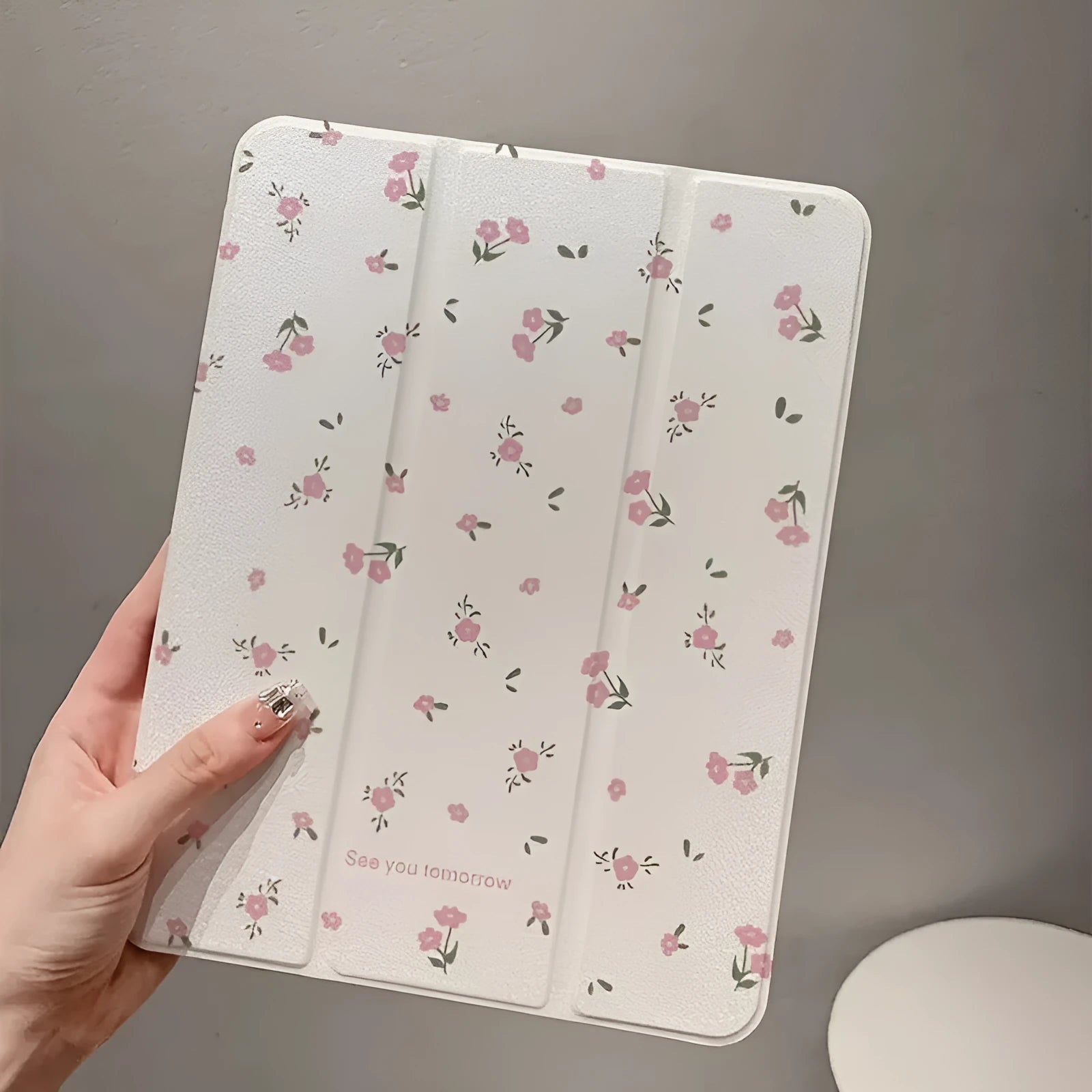 Transparent floral print hard case for iPad with tri-fold magnetic front cover acting as a kickstand.