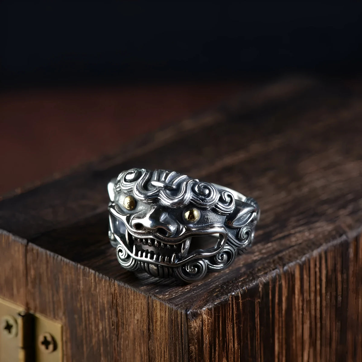Domineering open ring with engraved animal pattern on wide sterling silver band, shown on a finger.